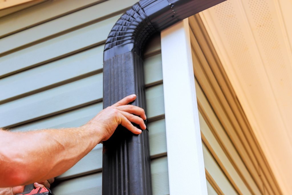 on,roof,,worker,is,installing,rain,gutter,fitting,downpipe,downspout on,roof,,worker,is,installing,rain,gutter,fitting,downpipe,downspout